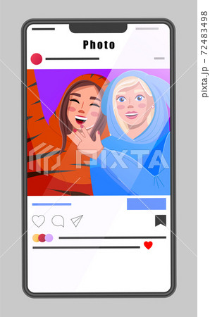 Smartphone with interface of photo social network, media account, selfie of happy girls in costumes 72483498