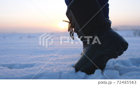 Male feet walking in deep snow. foot steps of hiker. recreational winter activity Male feet walking in deep snow. foot steps of hiker. recreational winter activity 72485563