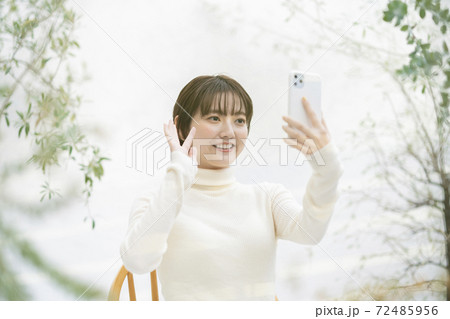 スマートフォンを使ってビデオ通話する女性 スマートフォンを使ってビデオ通話する女性 72485956