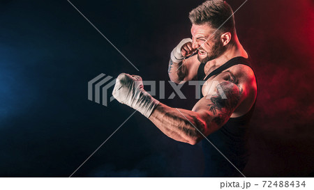 Sportsman muay thai boxer fighting on black background with smoke. Sport concept Sportsman muay thai boxer fighting on black background with smoke. Sport concept 72488434