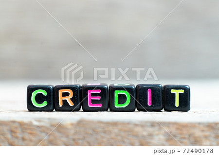 Black bead with color letter in word credit on wood background Black bead with color letter in word credit on wood background 72490178