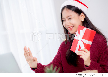 Young asian woman selfie video call online with friends and show red gift box in Christmas day. 72490949