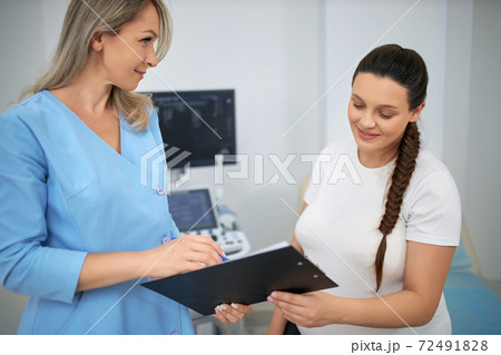 Skillful doctor providing examination for pregnant woman 72491828