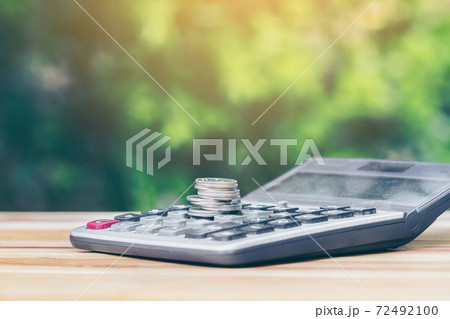 coin is placed is on the calculator. Indicates business growth and savings. planning savings money of coins to buy a home concept for property, mortgage, real estate, invest or saving for a buy house. coin is placed is on the calculator. Indicates business growth and savings. planning savings money of coins to buy a home concept for property, mortgage, real estate, invest or saving for a buy house. 72492100
