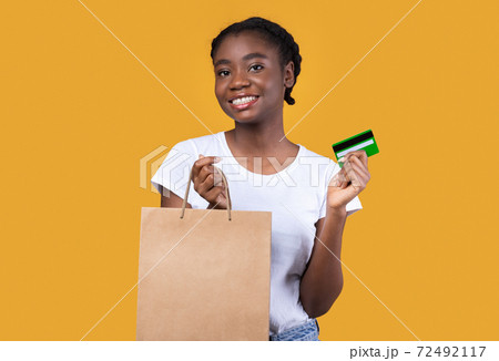 Woman Posing With Credit Card And Shopping Bag, Yellow Background 72492117