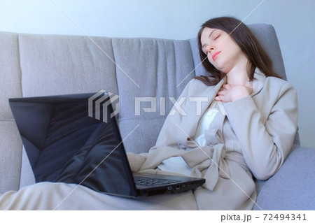 Tired woman sleeping working on laptop sitting on couch at home, distant work. 72494341