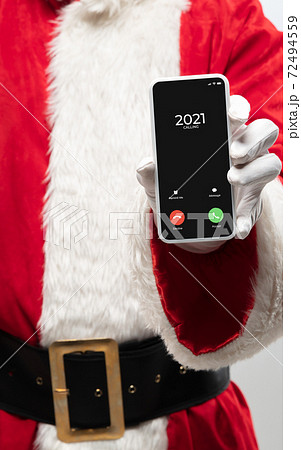 Close up hands of Santa Claus holding device with incoming call from 2021 year 72494559