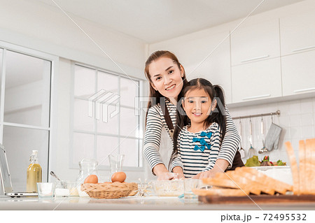 Happy Asian Mother and daughter is making flour for Bakery and bread in home kitchen for parenting concept. Happy Asian Mother and daughter is making flour for Bakery and bread in home kitchen for parenting concept. 72495532