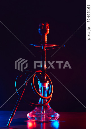 glass hookah with a metal bowl with hot coals on a black background on a table 72496161