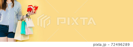 web banner beauty asian 30s to 40s woman hold shopping bag and her gift box with happiness feeling with yellow pastel background web banner beauty asian 30s to 40s woman hold shopping bag and her gift box with happiness feeling with yellow pastel background 72496289