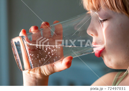 Little girl drinking a fresh glass of water Little girl drinking a fresh glass of water 72497031
