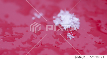 Snowflakes during the snowfall on glass surface 72498871