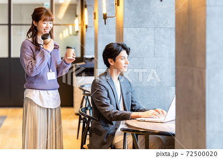 オフィスで同僚にコーヒーを勧める女性 オフィスで同僚にコーヒーを勧める女性 72500020