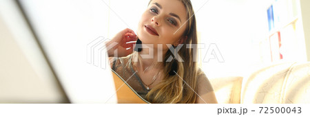 Beautiful young woman playing guitar at home Beautiful young woman playing guitar at home 72500043