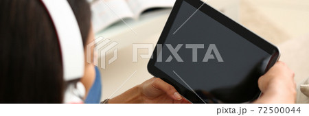 Young woman in headphones using tablet computer Young woman in headphones using tablet computer 72500044