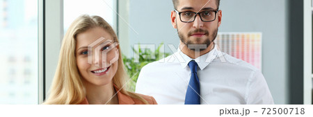 Joyful business colleagues standing in modern office Joyful business colleagues standing in modern office 72500718