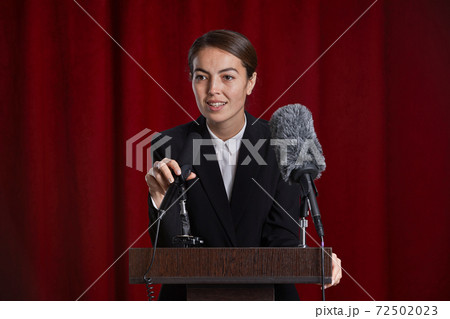 Young Woman Giving Speech on Stage Young Woman Giving Speech on Stage 72502023