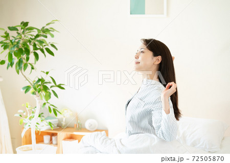 寝室で目覚める若い女性 72505870