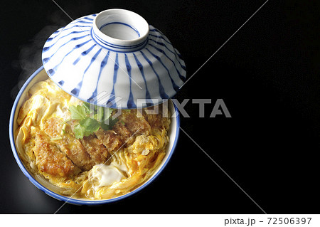 丼ぶりに入った熱々のカツ丼を黒背景で単品撮影（俯瞰） 72506397