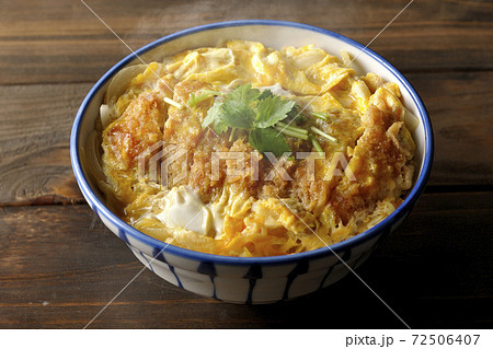 三つ葉が乗っている熱々のかつ丼 72506407