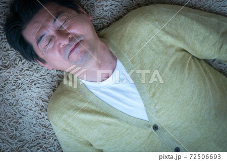 仰向けに寝そべる中高年男性 72506693