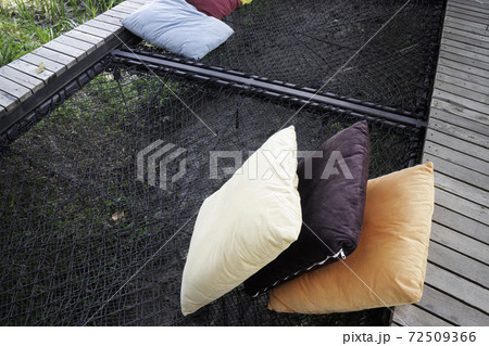 Colorful pillows on net seat among nature 72509366