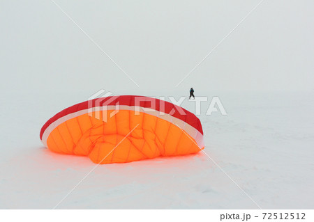 Man training with a kite on frozen river Man training with a kite on frozen river 72512512