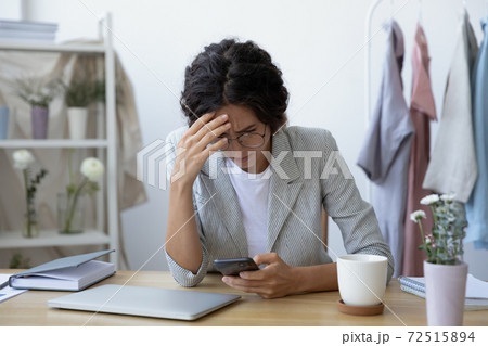 Concerned young woman florist tailor getting email with bad news 72515894
