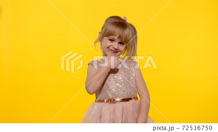 Little smiling blonde child kid girl showing thumb up isolated on yellow background Little smiling blonde child kid girl showing thumb up isolated on yellow background 72516750