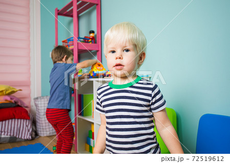 The children take turns playing with toys in the kindergarten The children take turns playing with toys in the kindergarten 72519612