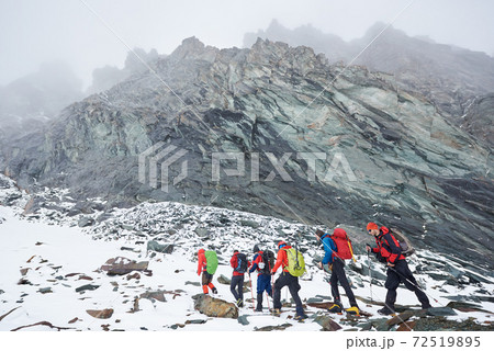 Hikers walking at the bottom of Grossglockner mountain. Hikers walking at the bottom of Grossglockner mountain. 72519895