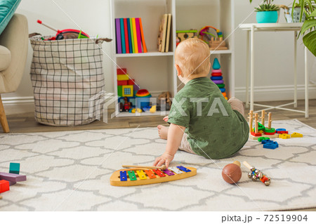 The toddler boy chooses toys in the playroom 72519904
