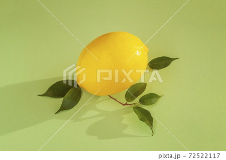 One yellow lemon on tender green background, top view. Juicy natural summer vitamin and diet concept 72522117