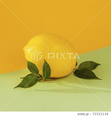 Ripe lemon with a leaf on bicolor multicolored background. Juicy summer vitamin C, citrus minimal concept. Ripe lemon with a leaf on bicolor multicolored background. Juicy summer vitamin C, citrus minimal concept. 72522118