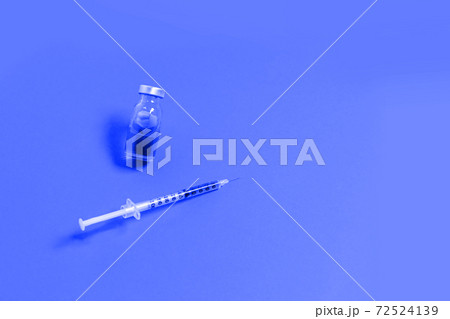 Syringe with blue medicine liquid on an isolated blue background. Vaccination, immunity, cosmetology concept 72524139