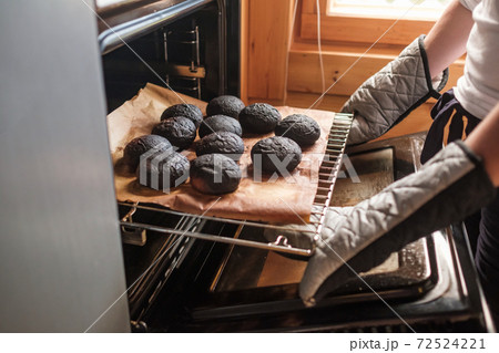 Failed cooking in kitchen. Woman holding a tray of spoiled muffins 72524221