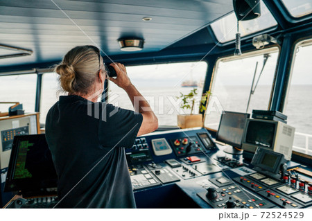 Captain of vessel or ship. He is looking through binoculars Captain of vessel or ship. He is looking through binoculars 72524529