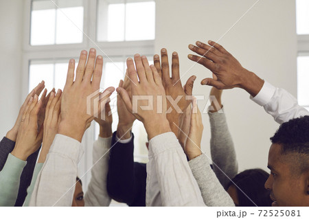 Team of multiracial people raising hands up in the air, showing solidarity, unity and support Team of multiracial people raising hands up in the air, showing solidarity, unity and support 72525081
