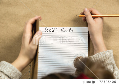Open Notebook writing 2021 New Year goals Close up on brown background, Business or education motivation, inspiration concept. New Year goals and resolutions setting. retro modern design Open Notebook writing 2021 New Year goals Close up on brown background, Business or education motivation, inspiration concept. New Year goals and resolutions setting. retro modern design 72526406