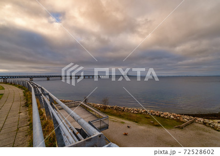 The Oresund Bridge, the bridge and underwater tunnel connecting Malmo, Sweden with Copenhagen, Denmark. A beautiful sunset sky in the background The Oresund Bridge, the bridge and underwater tunnel connecting Malmo, Sweden with Copenhagen, Denmark. A beautiful sunset sky in the background 72528602