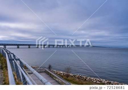 The Oresund Bridge, the bridge and underwater tunnel connecting Malmo, Sweden with Copenhagen, Denmark. A beautiful sunset sky in the background 72528681