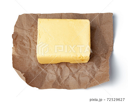 Fresh butter on craft paper isolated on white background Fresh butter on craft paper isolated on white background 72529627