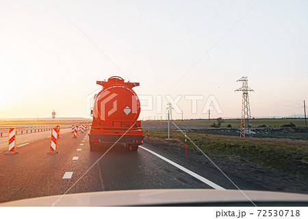Truck driving on highway road at sunrise 72530718