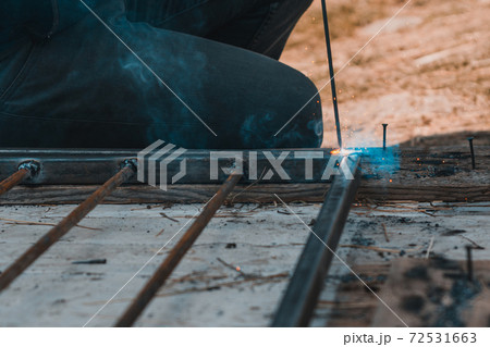 Welding a metal profile at home, a man welds metal to design an aviary for a dog. Welding a metal profile at home, a man welds metal to design an aviary for a dog. 72531663