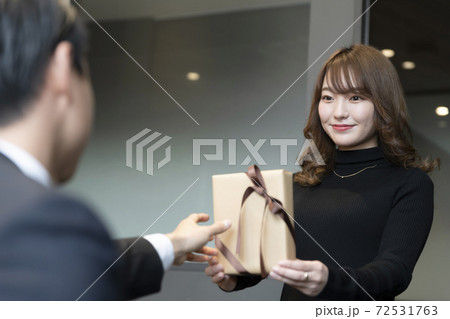 バレンタインのチョコを上司に手渡しする20代女性部下 バレンタインのチョコを上司に手渡しする20代女性部下 72531763