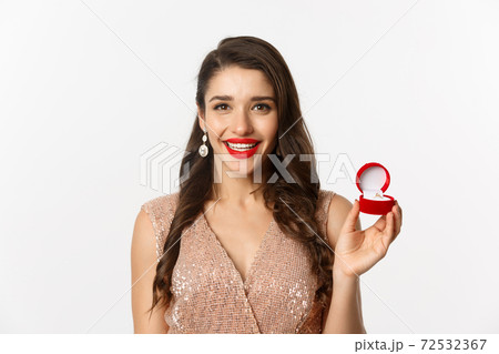Close-up of beautiful brunette woman showing engagement ring, wearing elegant dress, receive marriage proposal, white background Close-up of beautiful brunette woman showing engagement ring, wearing elegant dress, receive marriage proposal, white background 72532367