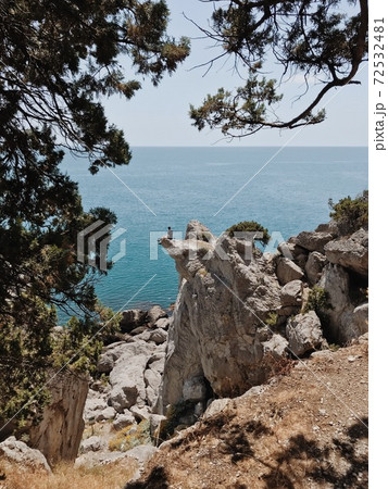 Man sitting on the cliff edge Man sitting on the cliff edge 72532481