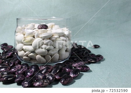 white beans in a glass jar and red blue on mint light background of a copy of the space 72532590