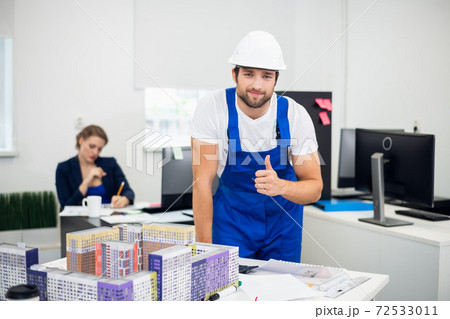 A construction worker in the office showing thumbs up A construction worker in the office showing thumbs up 72533011