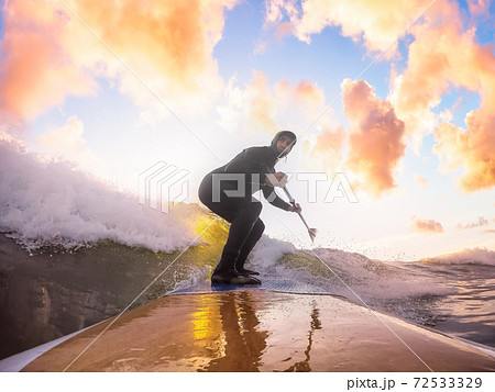 Adventurous Man Surfing the waves at the Pacific Ocean 72533329